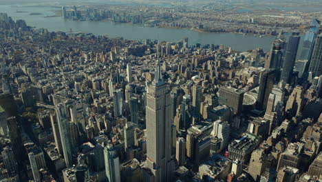 Aerial-panoramic-footage-of-cityscape.-Majestic-Empire-State-Building-towering-above-surrounding-development.-Manhattan,-New-York-City,-USA