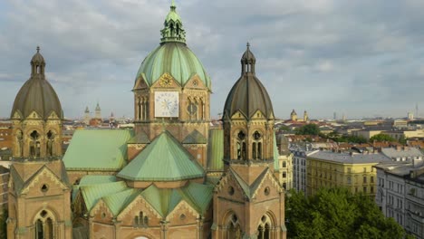 cinematic aerial shot of drone circling in front of st luke's church in munich, germany