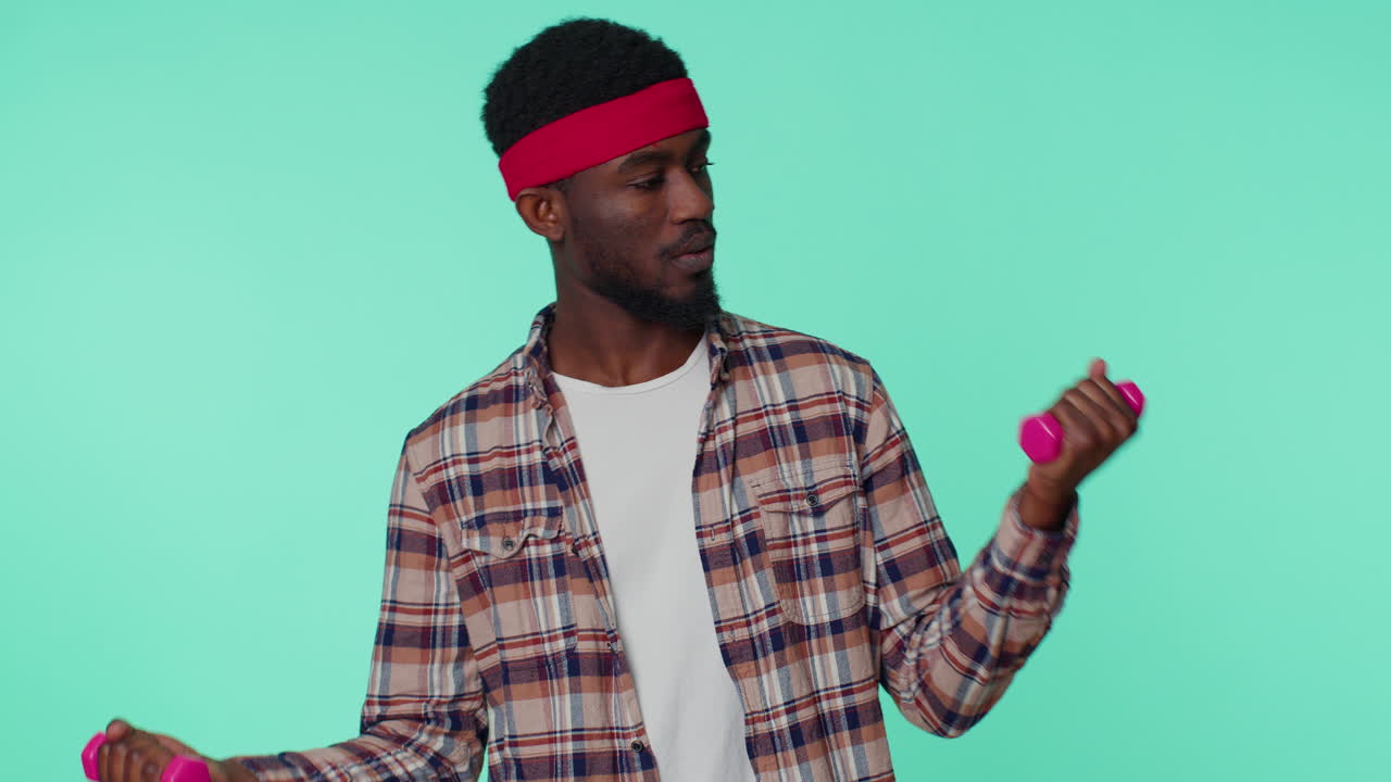 hombre afroamericano deportivo trabajando bombeando los músculos de los brazos levantando pesas practicando pilates