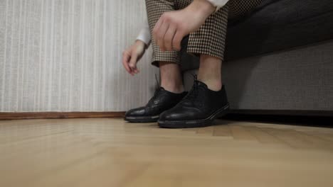 groom putting his wedding shoes on wedding day. hands of wedding groom