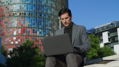 Businessman-opening-laptop-outdoors.-Manager-using-computer-on-urban-street