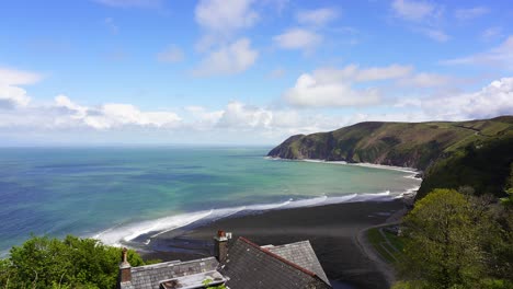 Blick-über-Die-Bucht-Von-Lynmouth-Von-Lynton-An-Einem-Schönen-Sommertag-Mit-Wellen,-Die-Auf-Den-Felsigen-Kiesstrand-Von-Blacklands-Beach-Rollen