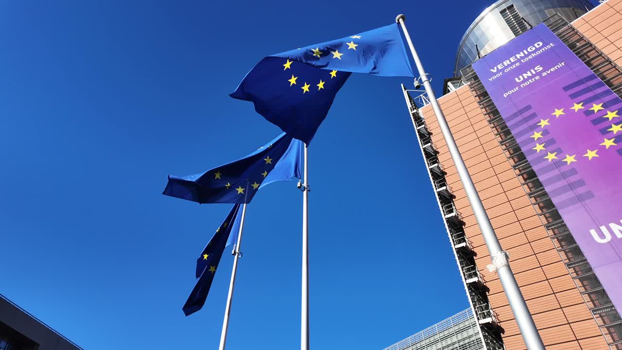 Low angle of EU flags waving in front of European Commission building