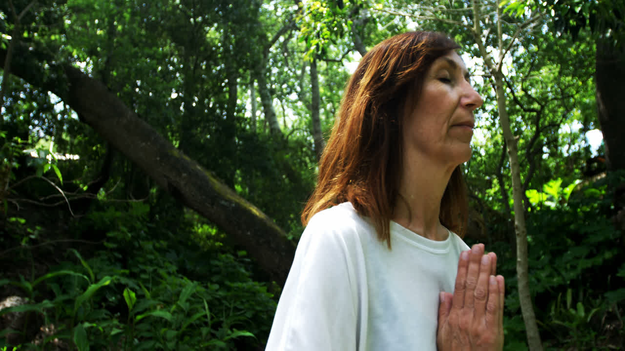 mujer madura haciendo yoga en el parque 4k