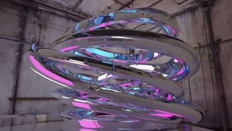 abstract metallic spiral sculpture with reflective pink and blue hues