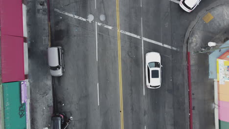 top down drone view of american downtown district street and cars turning on intersection