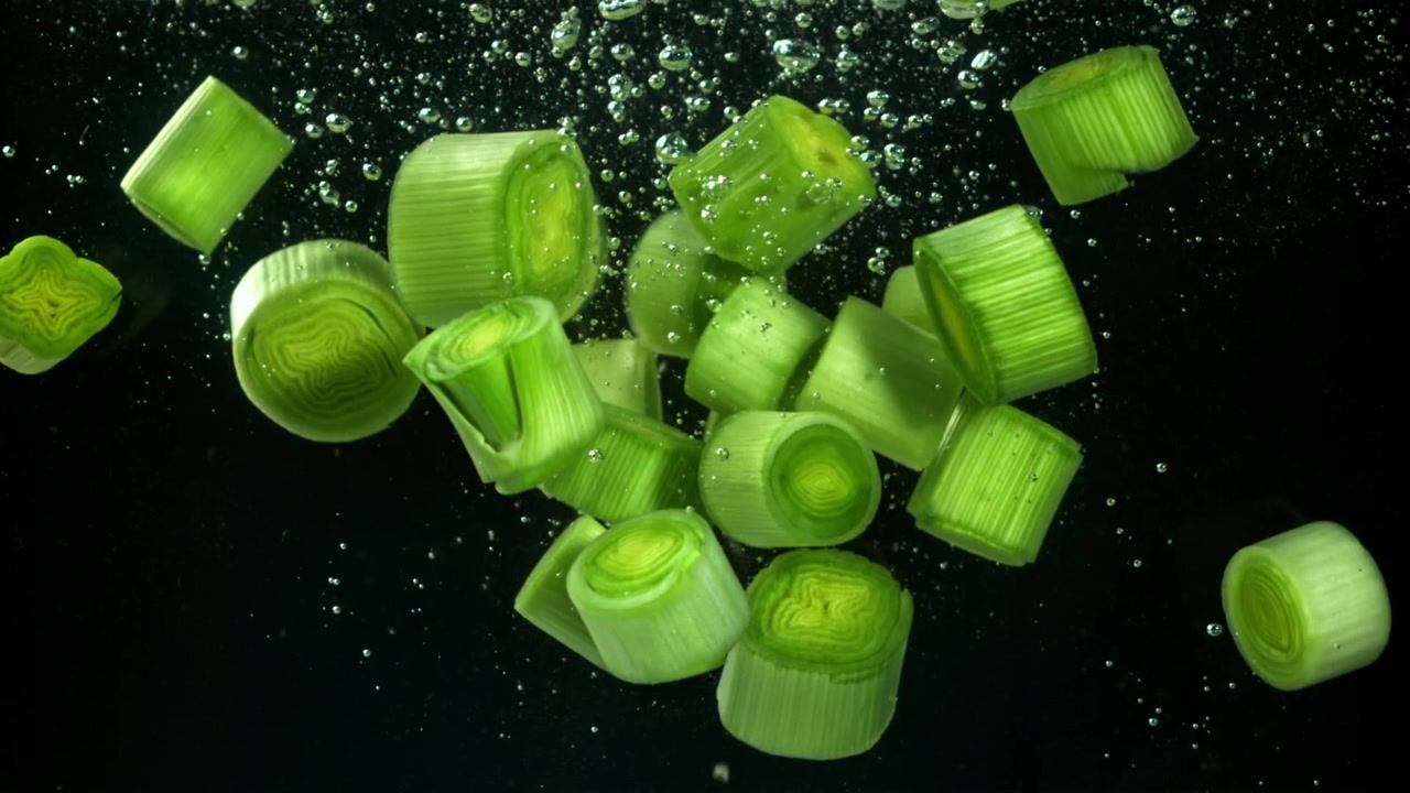 Porri freschi tritati che galleggiano nell'acqua con bolle