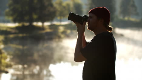 hombre caucásico tomando fotos de paisajes con cámara dslr - plano medio