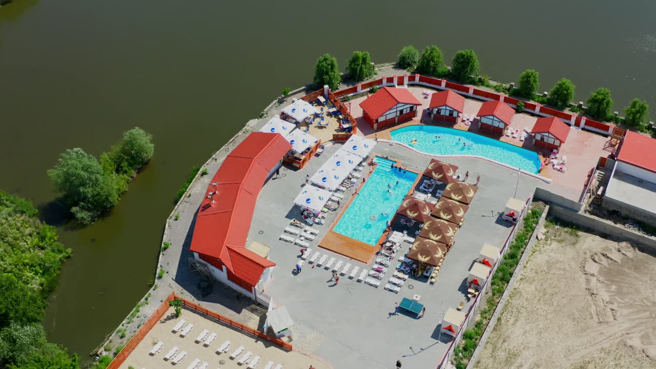 People in swimming pool. Aerial view of luxury vacation resort with pool