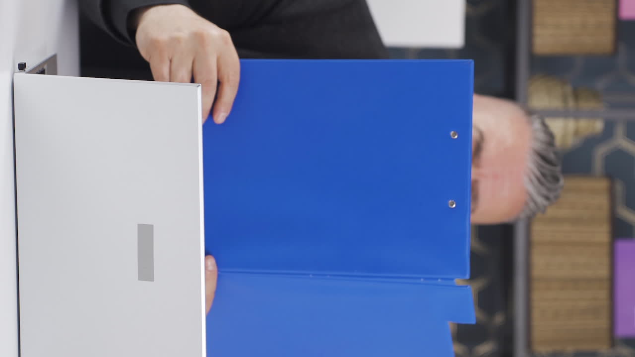 파일을 작업하는 쾌활한 사업가의 수직 비디오.