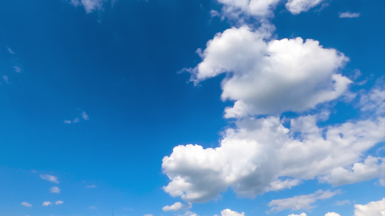 Amazing bright blue sky with little clouds flying through. Beautiful timelapse of fluffy clouds transformation.
