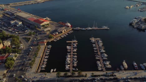 Aerial-of-port-with-docked-boats-in-Kavala,-Greece-at-sunset