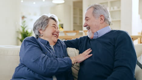 Mature,-man-and-woman-with-joke-in-home-on-sofa