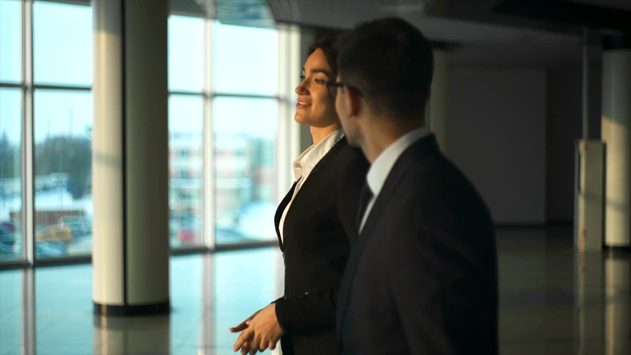 The business couple walking in the office hall. slow motion