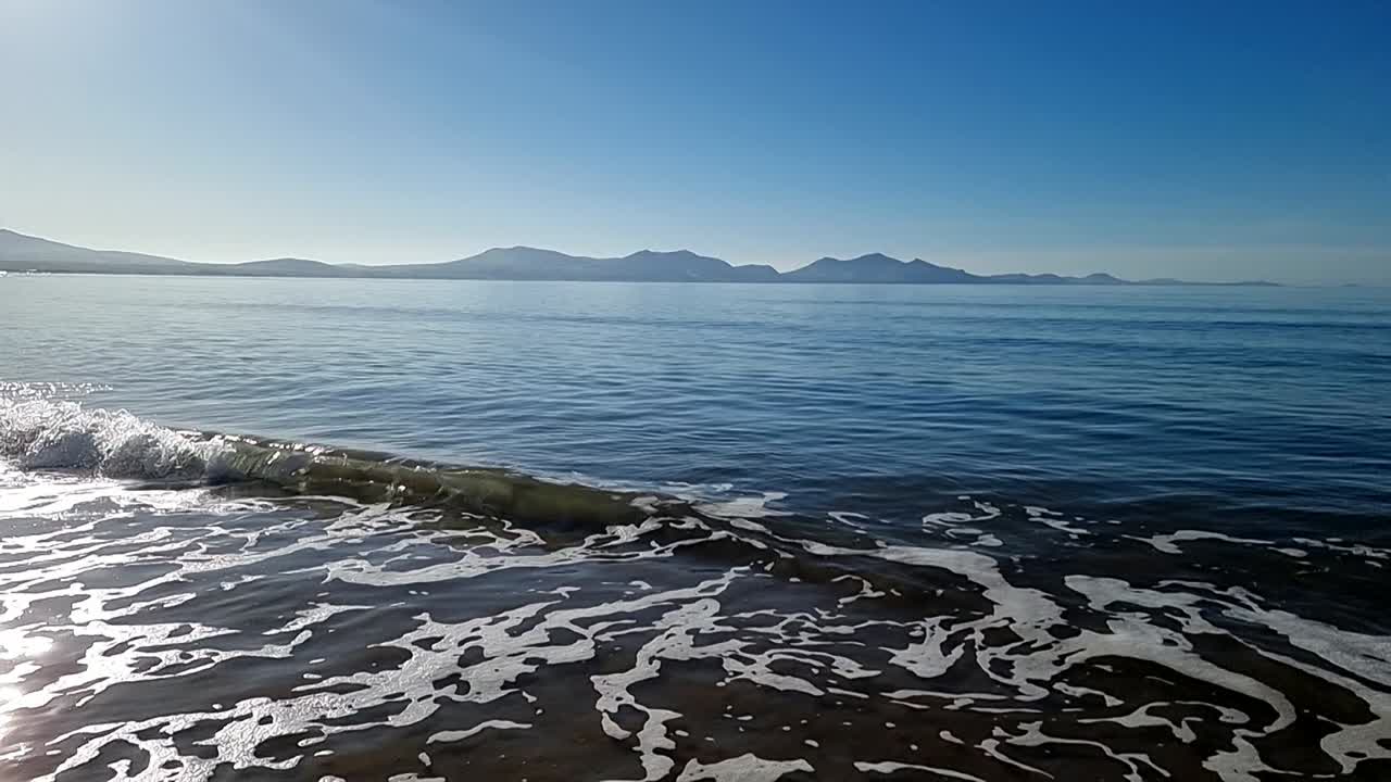 천천히 움직이는 조류 파도가 하늘의 안개 아래  ⁇ 아지는 아침 해가 뜨는 스노우도니아 산맥의 스카이라인