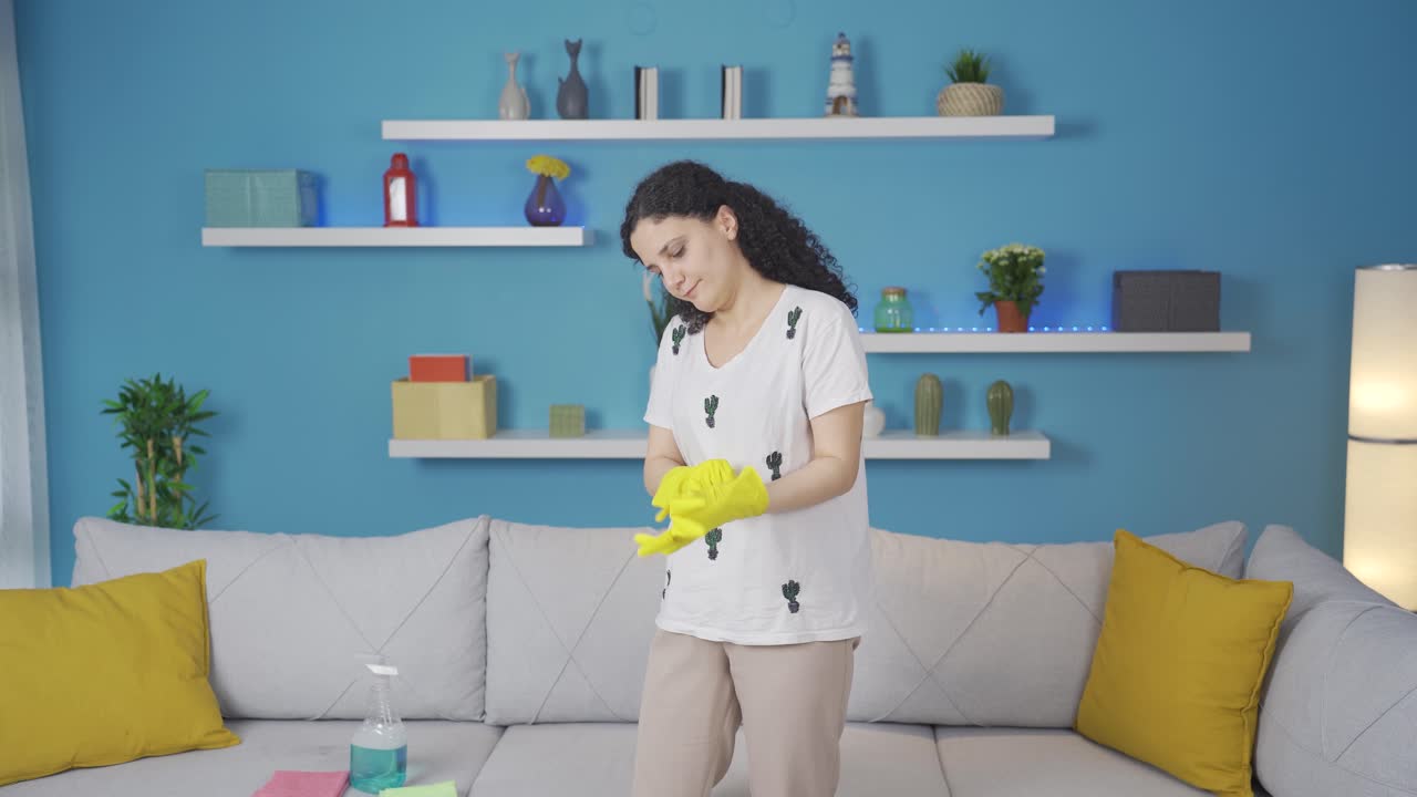 청소 장갑을 입은 젊은 여성.