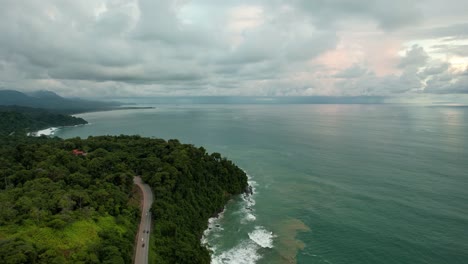 Carretera-entre-bosque-tropical-y-mar-de-agua-azul-verdosa