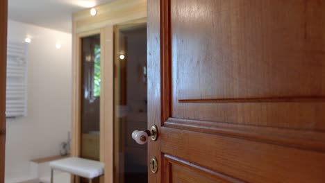 Slow-establishing-shot-of-a-door-revealing-a-small-wooden-sauna-within-a-house