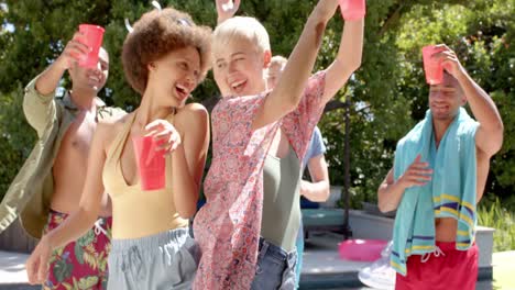 happy diverse group of friends having barbecue and dancing at pool party in summer