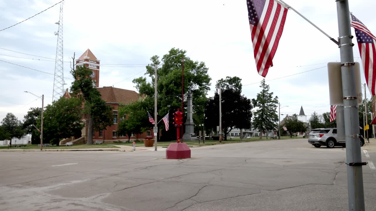 Semaforo antico a quattro vie e bandiera americana nel centro di Toledo, Iowa, con video stabile in campo lungo angolato.
