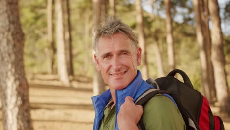 active senior looking at camera in forest