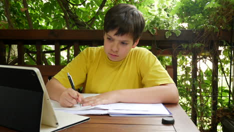 niño haciendo la tarea en el balcón