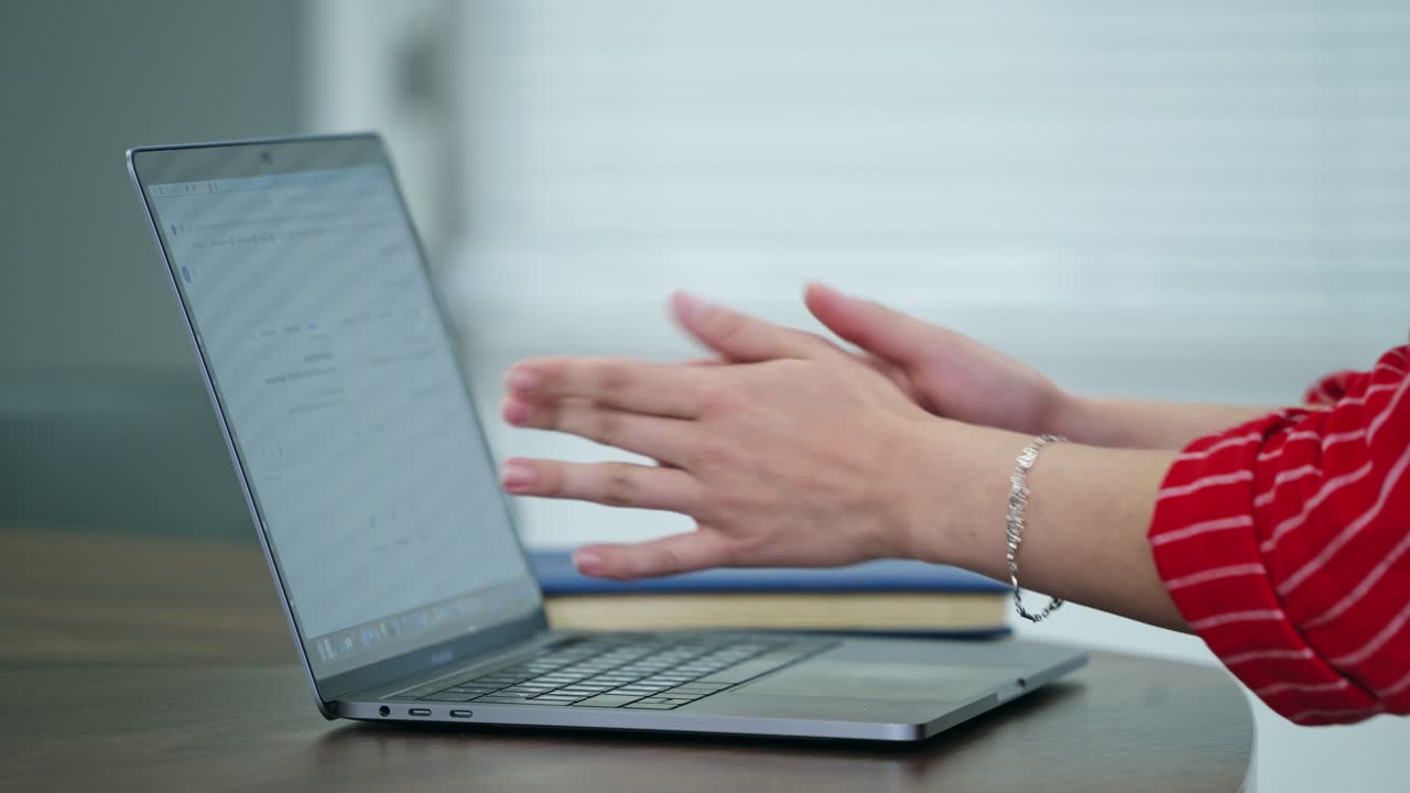 Woman's hands working on a laptop. Female feeling sudden pain in her hand. Businesswoman doing massage of her fingers and palm.