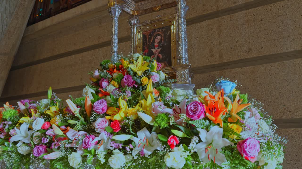Religious Icon of Virgin Mary Surrounded by Colorful Floral Arrangement