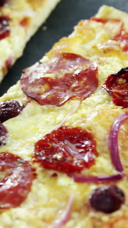 pizza italiana en una mesa de madera con verduras y especias