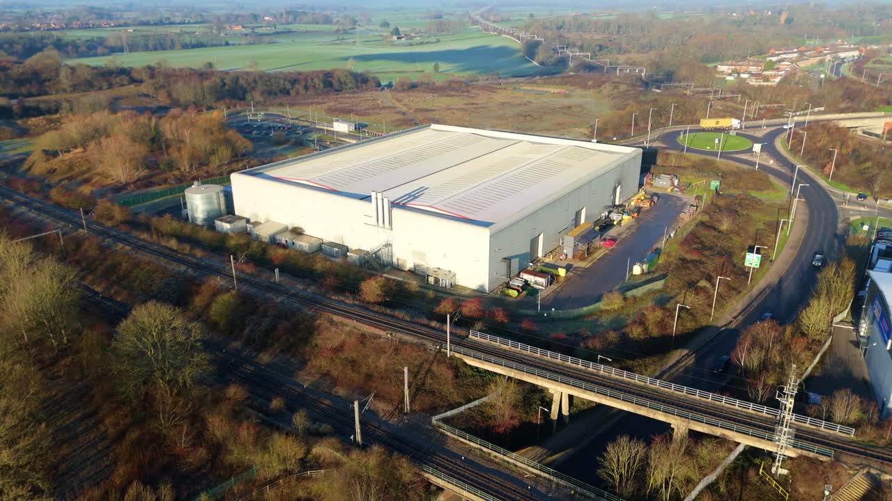 Ampia veduta aerea di un enorme centro di distribuzione e dei binari ferroviari adiacenti nel distretto industriale di Rugby.
