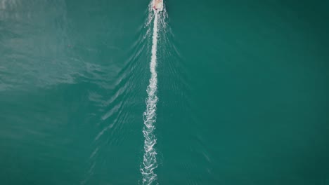 top down aerial view revealing boat sailing on calm lake