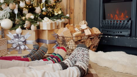 family relaxing by the fireplace during christmas