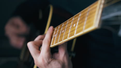 professional music teacher performs barre chords on guitar