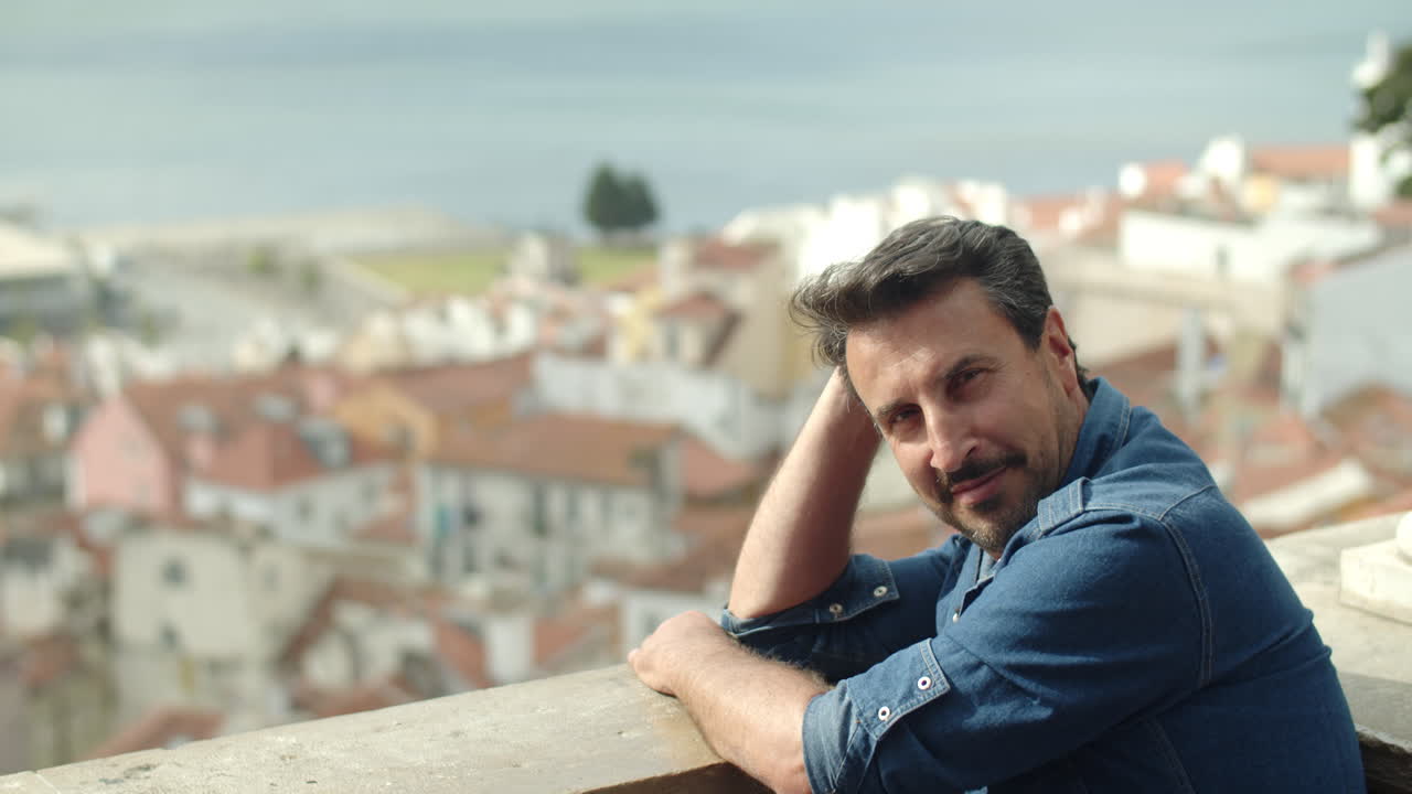 전망대에서 고대 도시를 바라보고 카메라에 포즈를 취하는 잠겨있는 남자