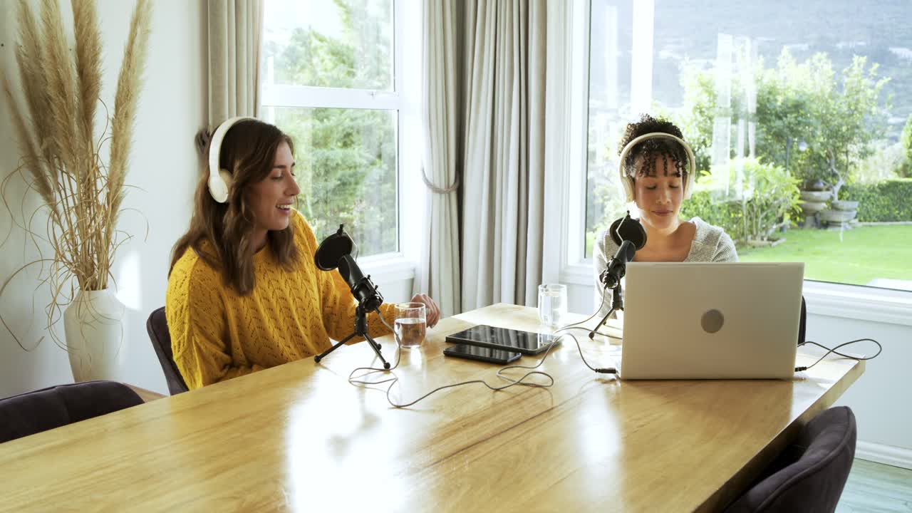 Diversas coanfitrionas ajustándose los auriculares en el estudio, bebiendo agua y hablando al micrófono para un podcast