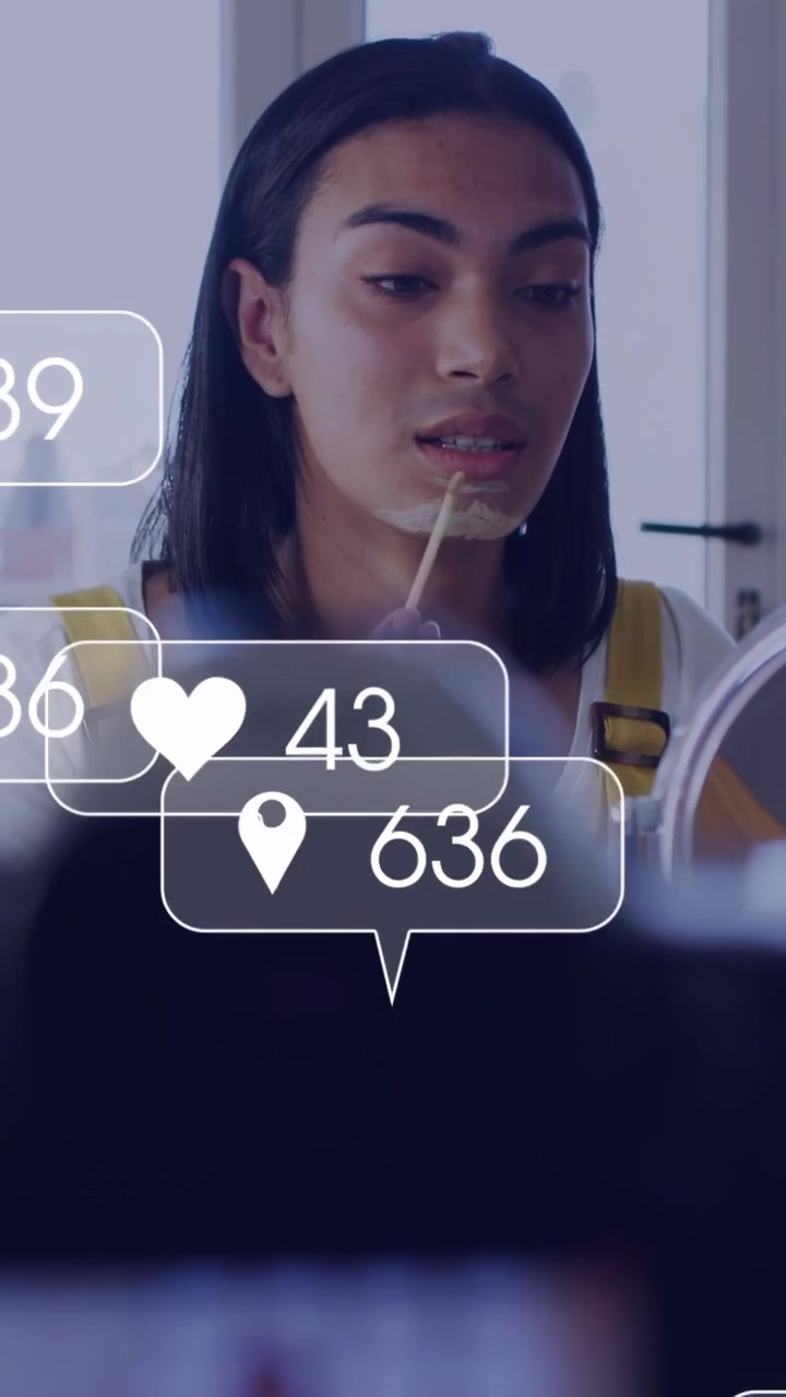 Vertical video: Cam focusing, beauty creator applying mask at mirror, likes floating, seeking fans