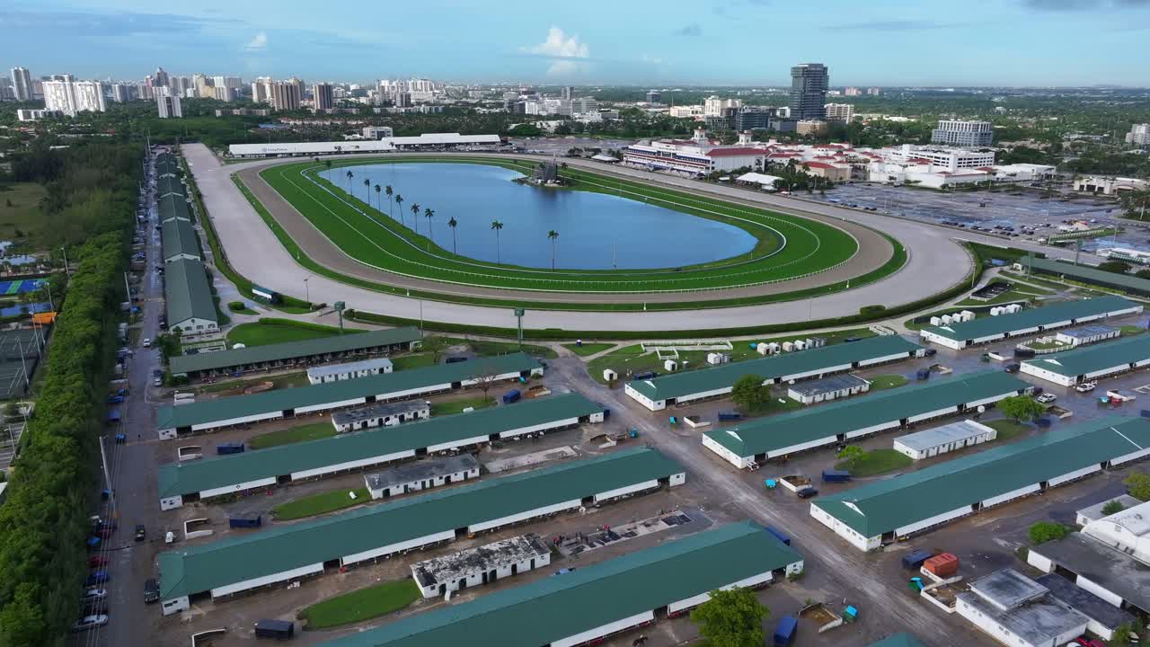Gulfstream Park Racetrack in Hallandale Beach, Florida. View includes the track, stables, and surrounding buildings. Aerial establishing shot.