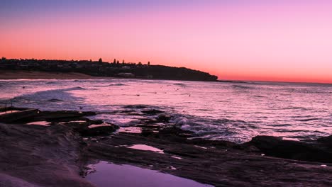 timelapse hyperlapse amanecer sobre el agua en curl curl beach con surfistas hermoso color rojo