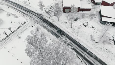 Drone-footage-of-car-driving-in-the-winter-forest-road