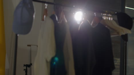 primer plano de la ropa del armario colgada en el riel durante el rodaje de una película o video en un estudio de cine