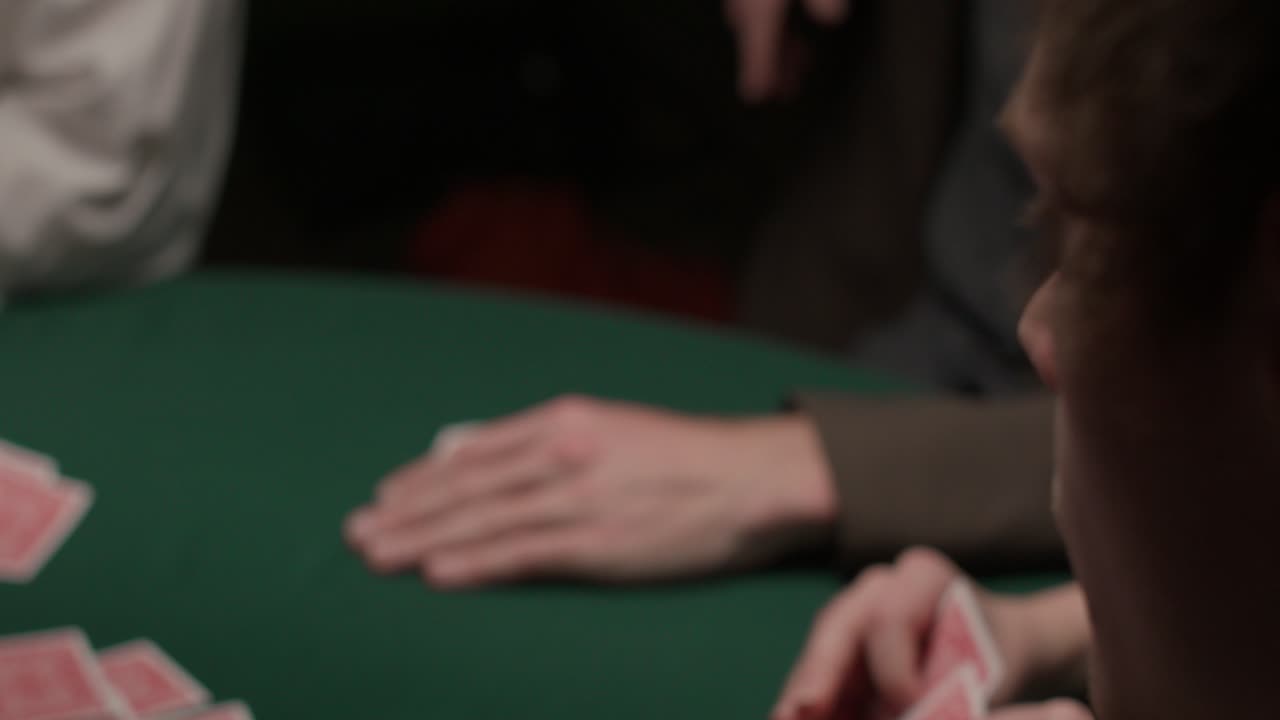 giocatore d'azzardo che pesca due carte in un casinò buio e lunatico sopra la sua spalla