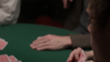 gambler drawing two cards in a dark moody casino over his shoulder