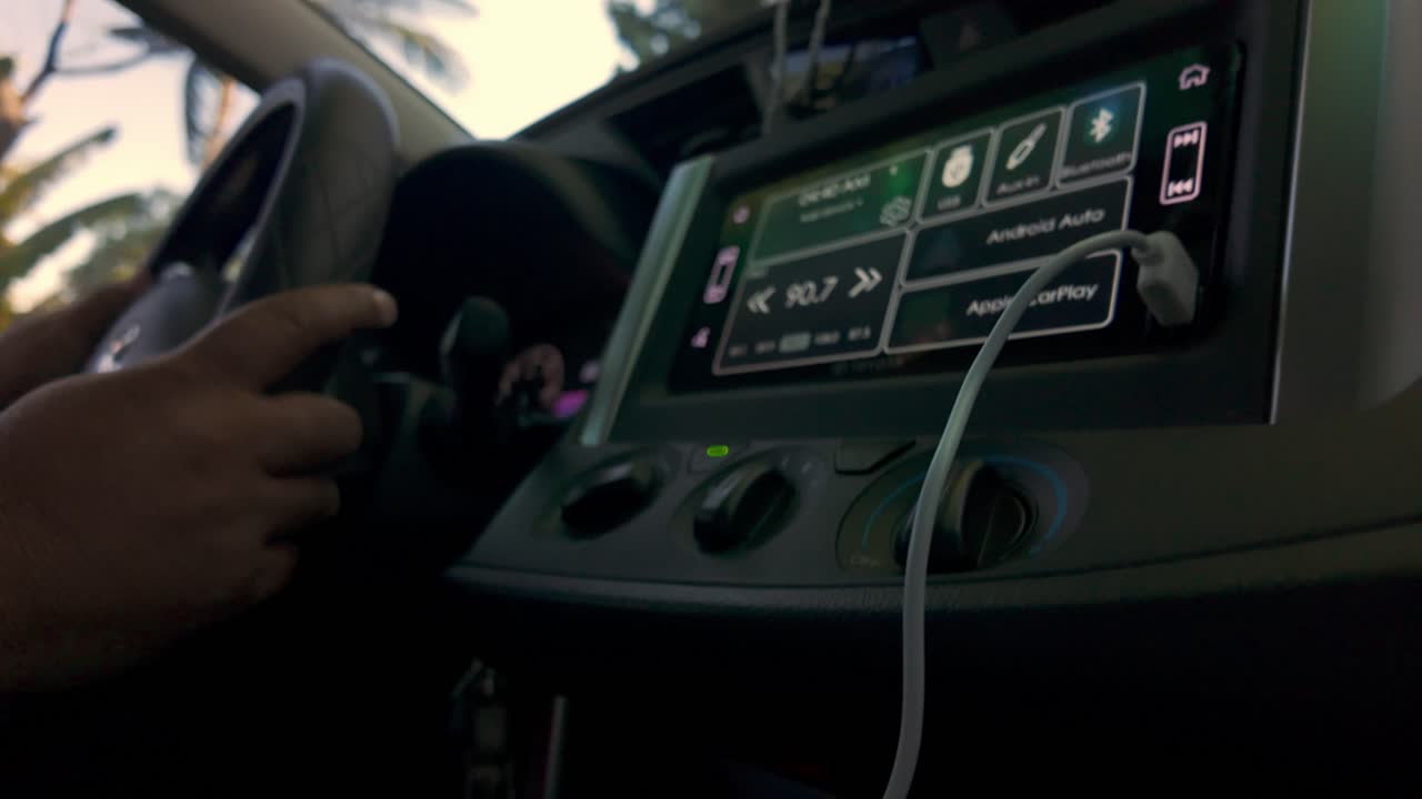 tome una vista del asiento del conductor dentro de un coche, mostrando el tablero de instrumentos, el volante y las manos del conductor en el control