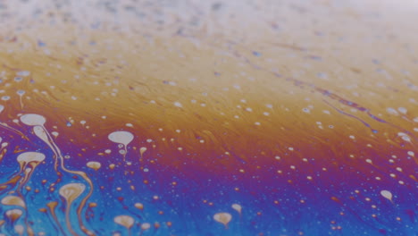 foto macro de un líquido viscoso con pequeñas gotas de aceite blanco en la superficie