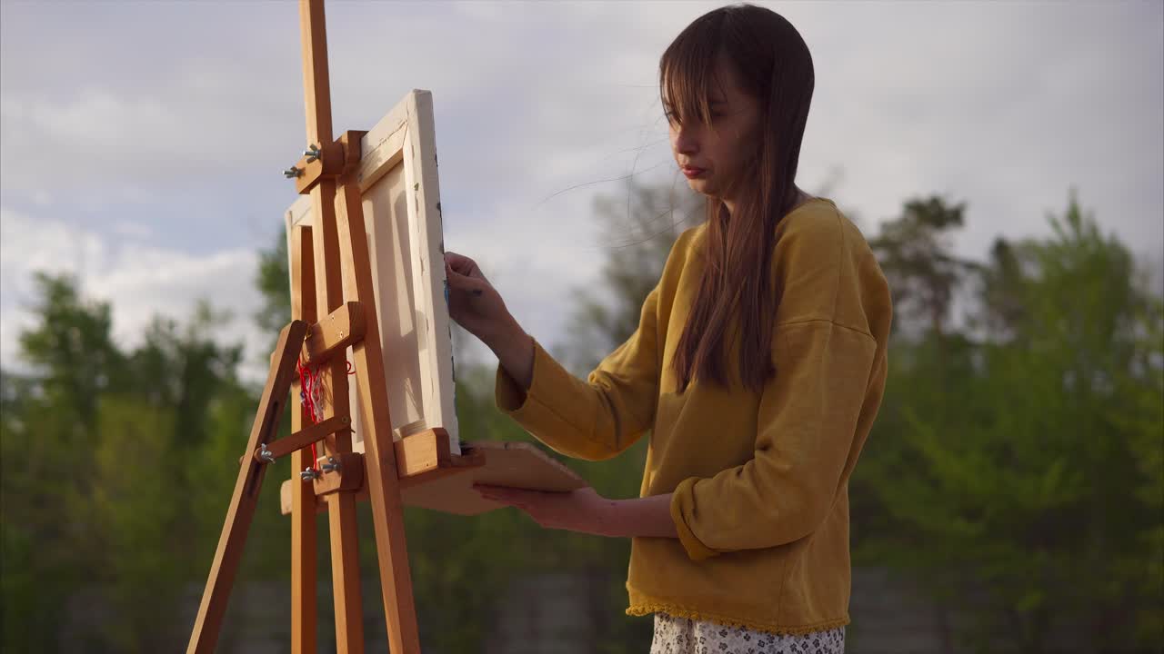 야외에서 그림을 그리는 젊은 예술가