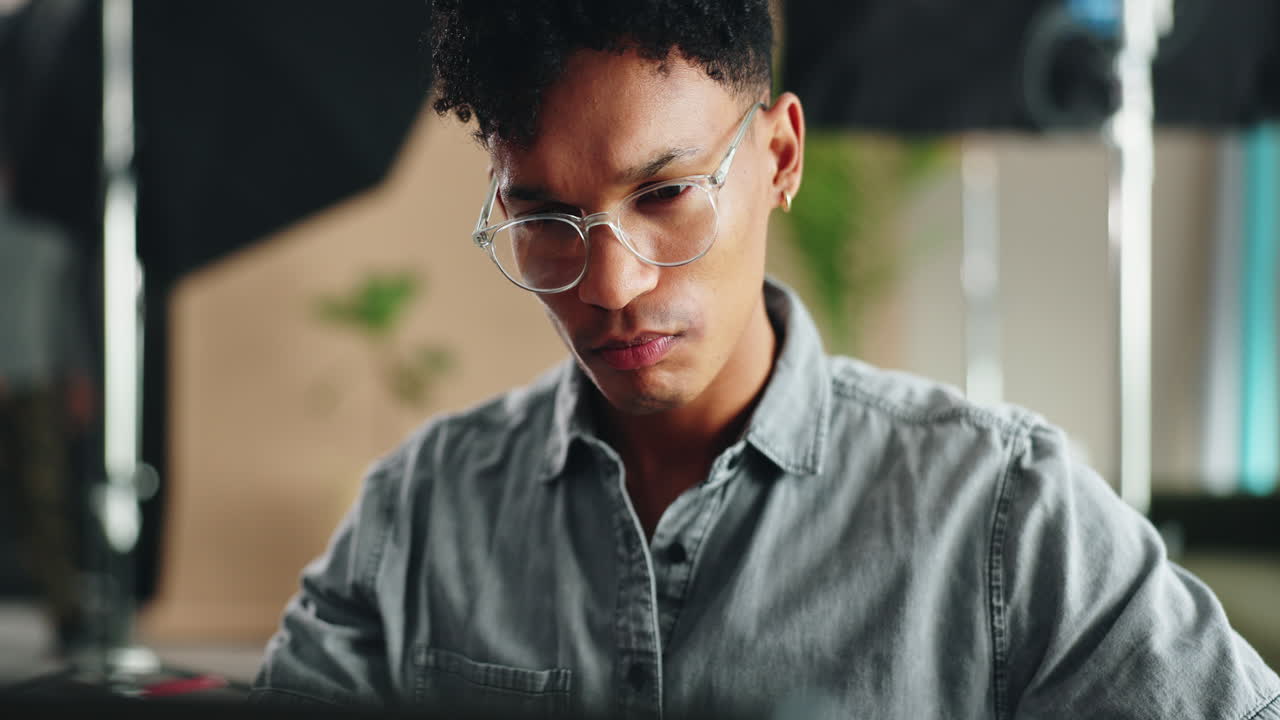 Young Professional Working on a Laptop in a Photography Studio