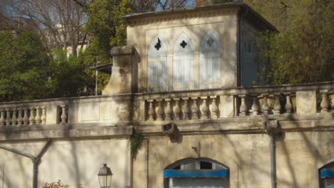 Slow-motion-shot-of-ancient,-abondoned-and-damaged-building-in-Montpellier-with-lots-of-greenery-around