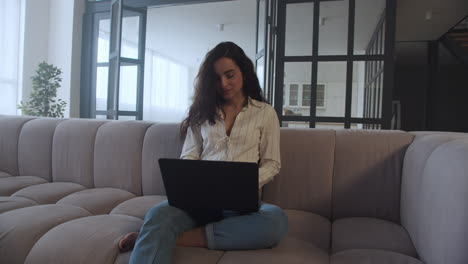 mujer joven trabajando en una computadora portátil en casa