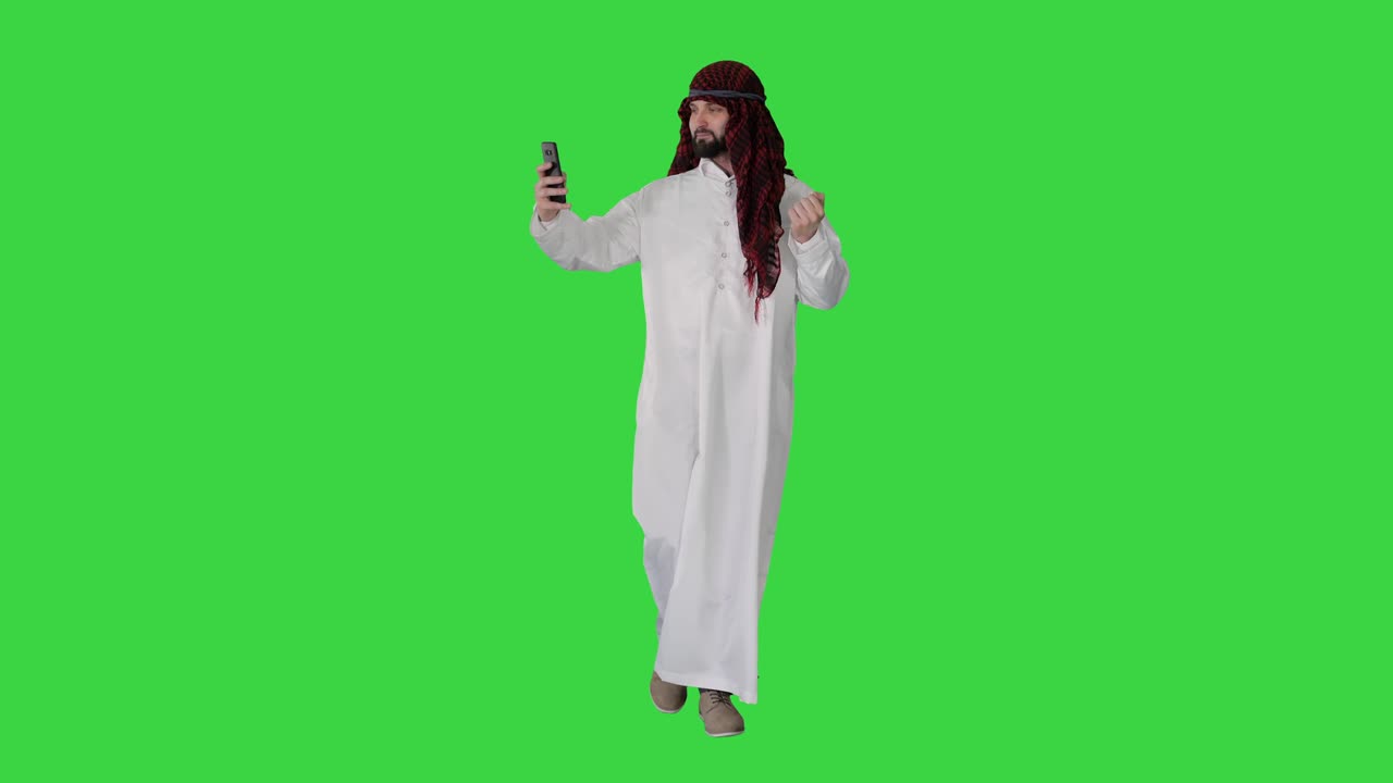 Uomo arabo che cammina e si fa un selfie con il suo telefono su Green Screen, Chroma Key