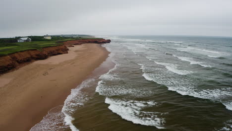 Vista-Aérea-De-Las-Olas-Que-Se-Acercan-A-La-Playa-Vacía-De-Thunder-Cove-En-Un-Día-Gris-Y-Nublado